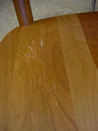 Close up of natural Cherry chairs with deep pressure dents and scratches