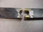A broken counter weight hinge, closeup.