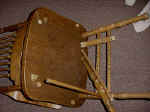 A reproduction oak chair with a broken leg and the bottom half was missing.